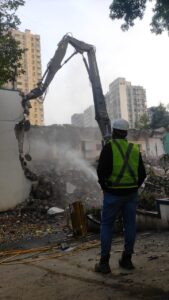 High reach demolition excavator demolishing an RCC building by Star Construction in India