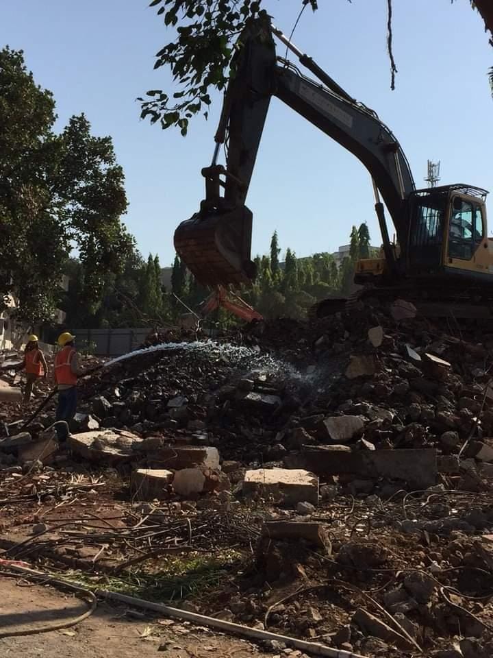 Excavator with bucket clearing demolition debris by Star Construction